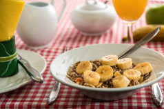 Photo of a bowl of cereal with sliced bananas on top Photo of a bowl of cereal with sliced bananas on top